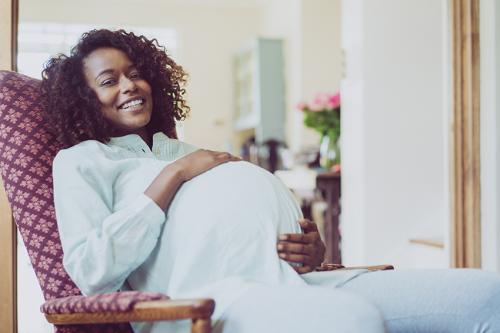 stock photo of a very pregnant woman in a rocking chair