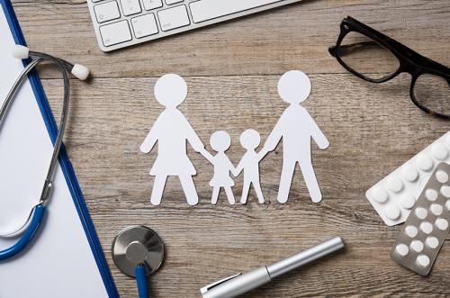 stock photo of paper cutout people on a desk with medical items 